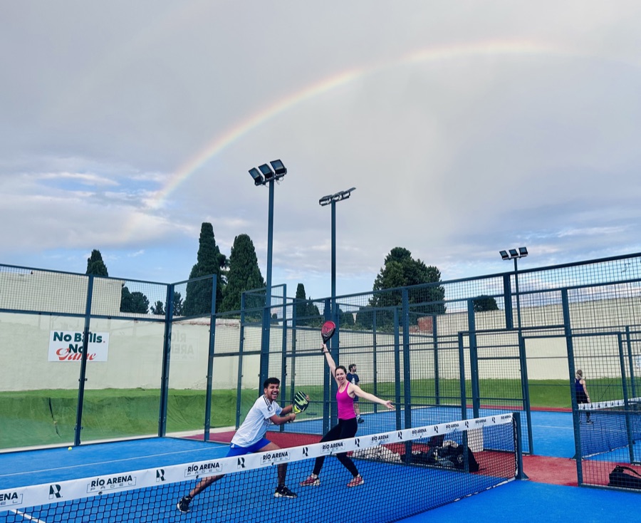 Padel players with a rainbow overhead